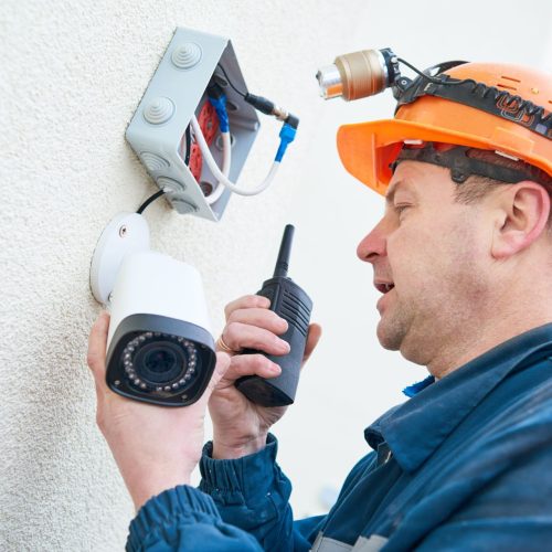 Technician,Worker,Installing,Video,Surveillance,Camera,On,Wall
